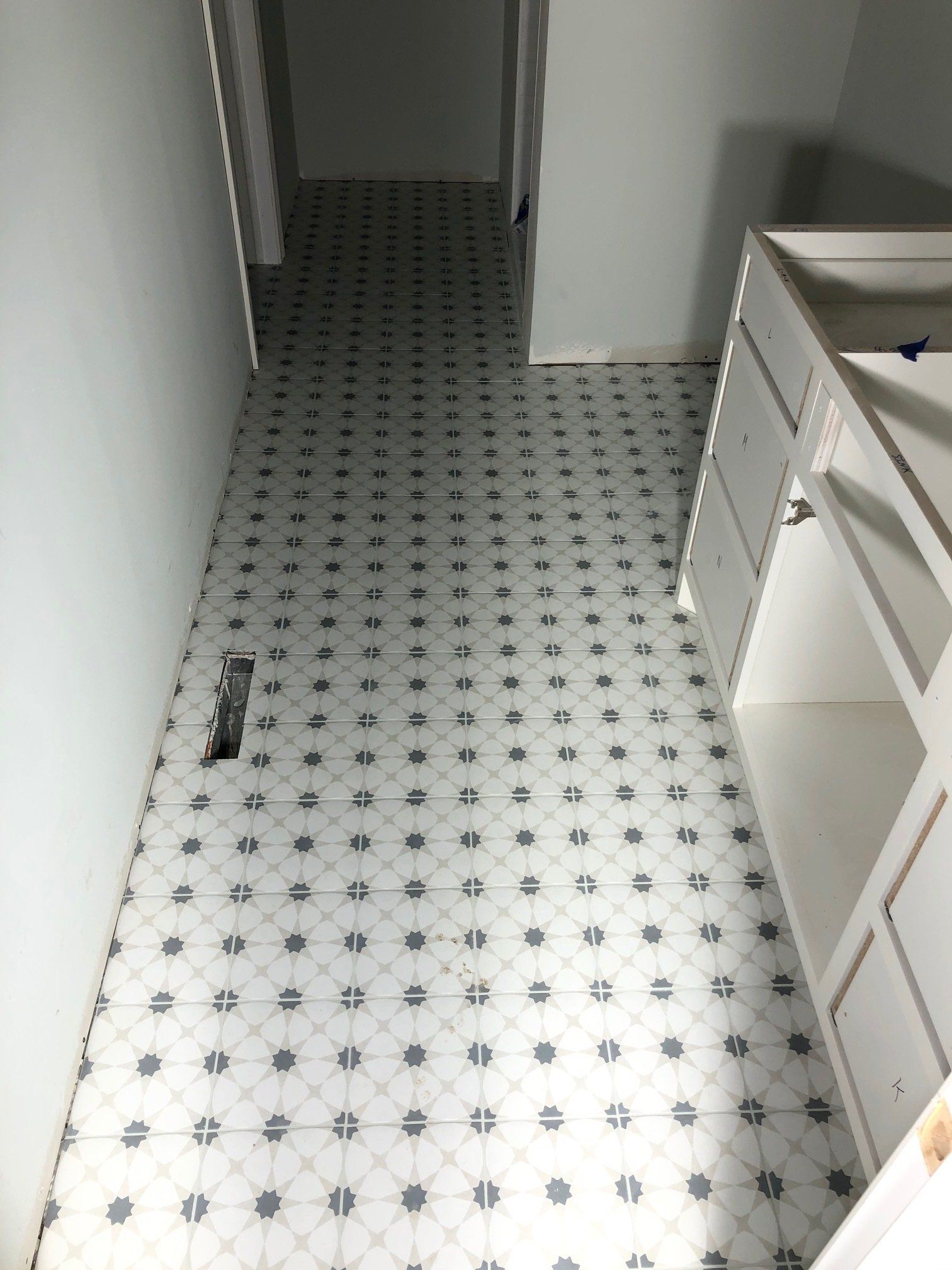 A bathroom with a white tile floor and a sink.
