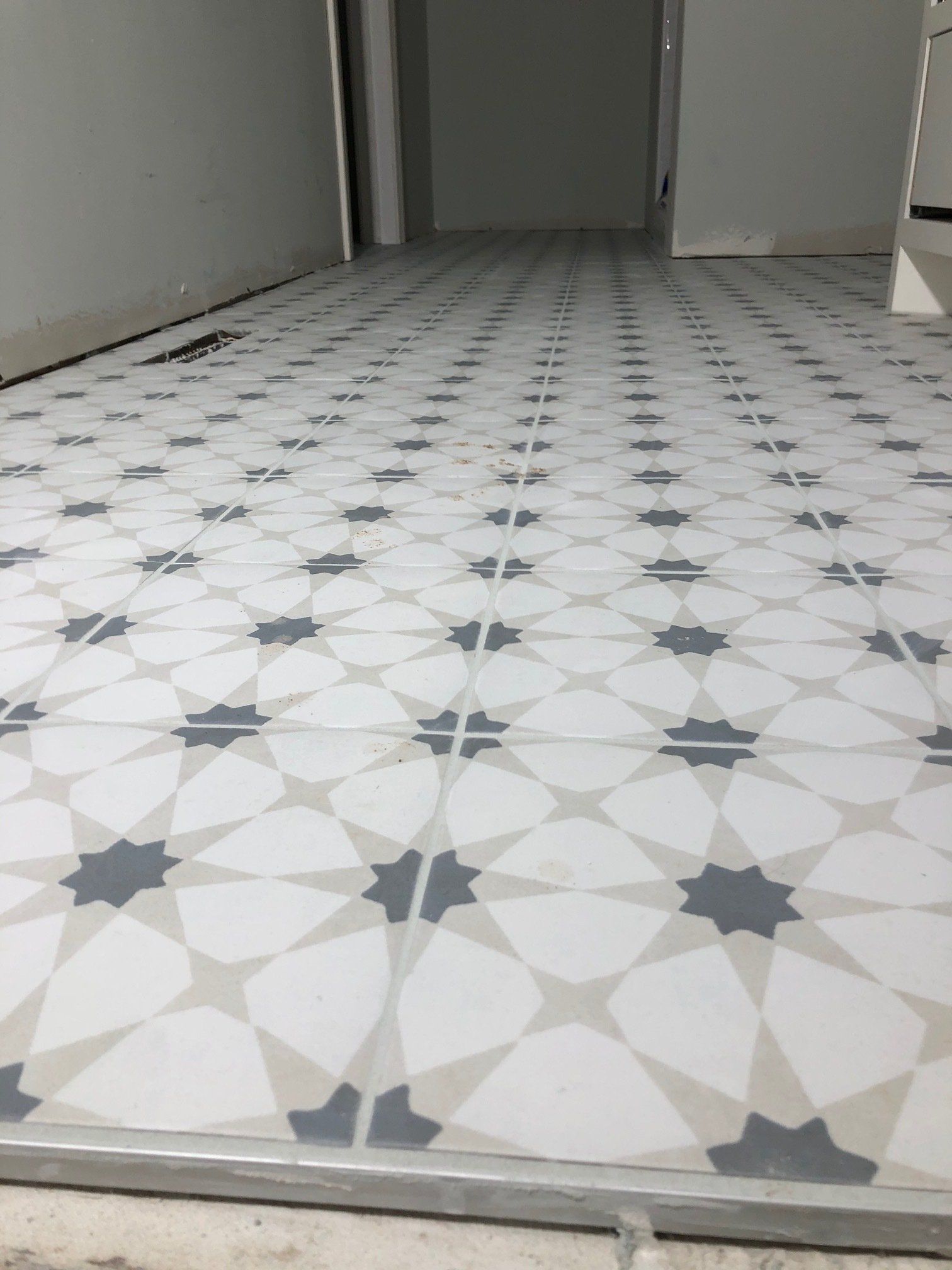 A white tile floor with a geometric pattern on it