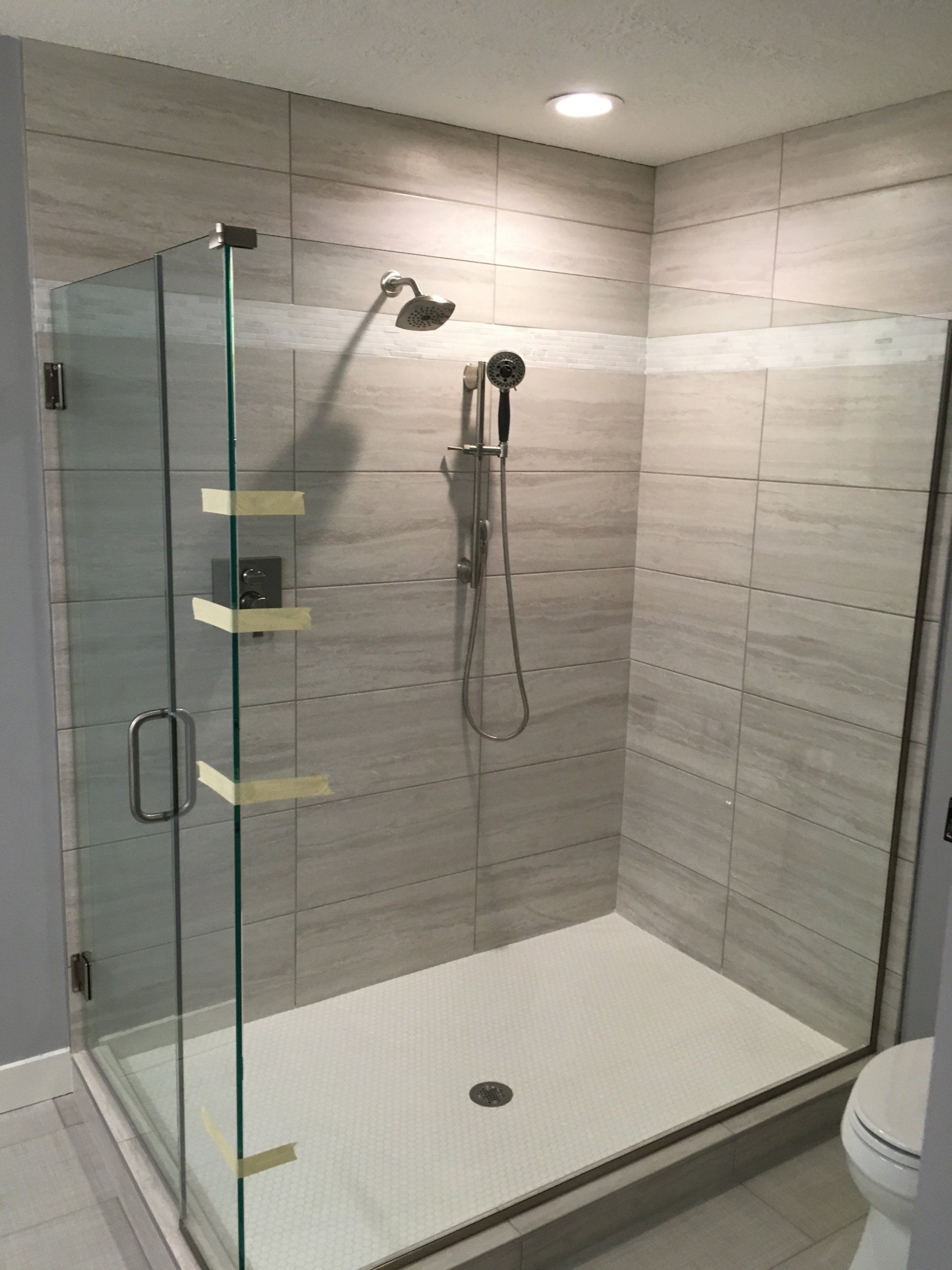 An accessible bathroom with a walk in shower and a toilet.