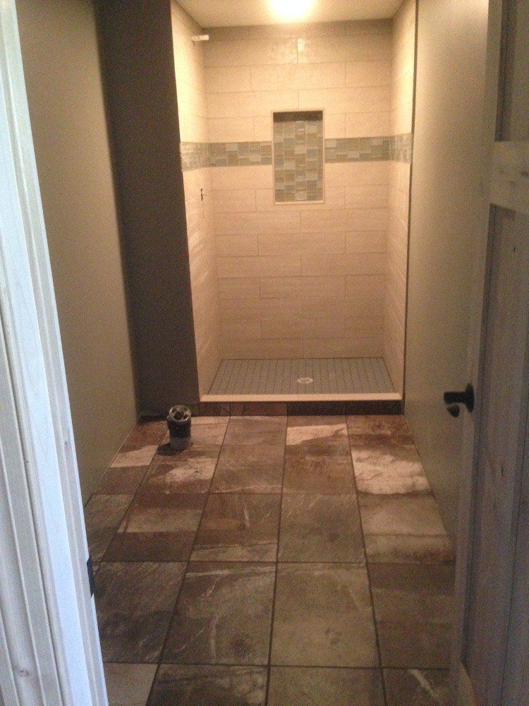 A bathroom redo with a tiled floor and a walk in shower.