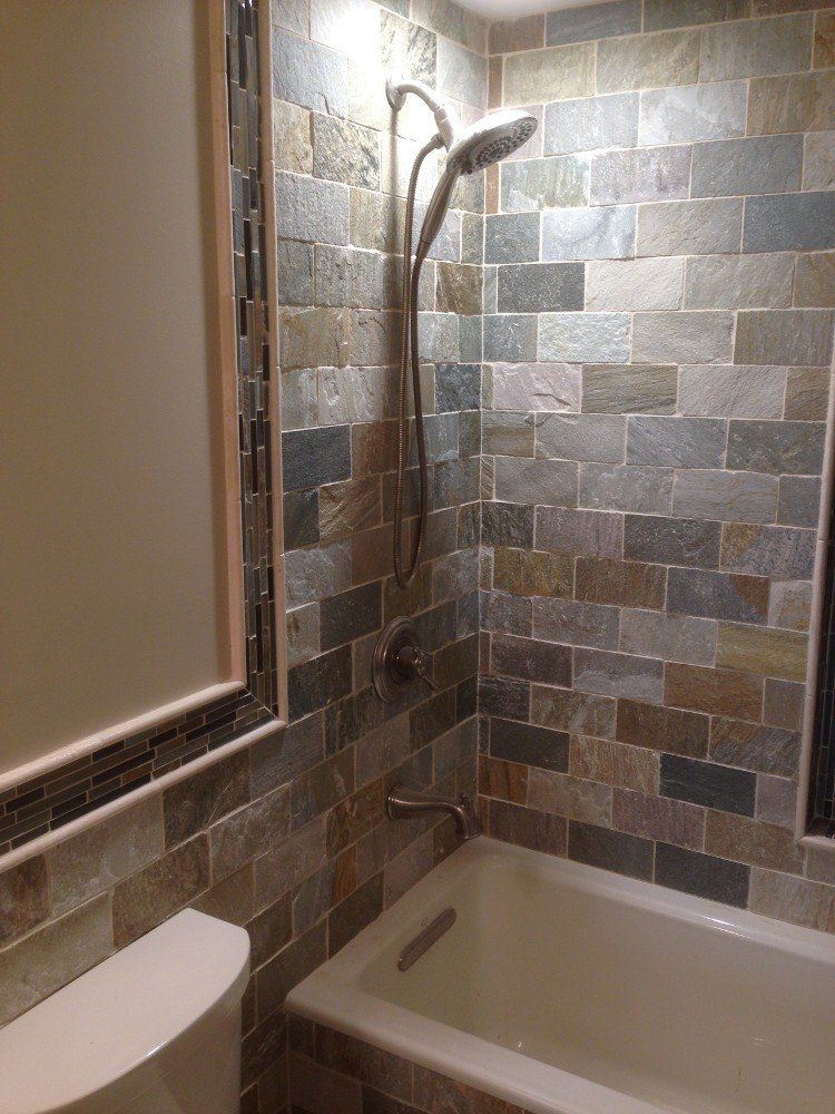 A bathroom with a tub , toilet , shower and mirror.