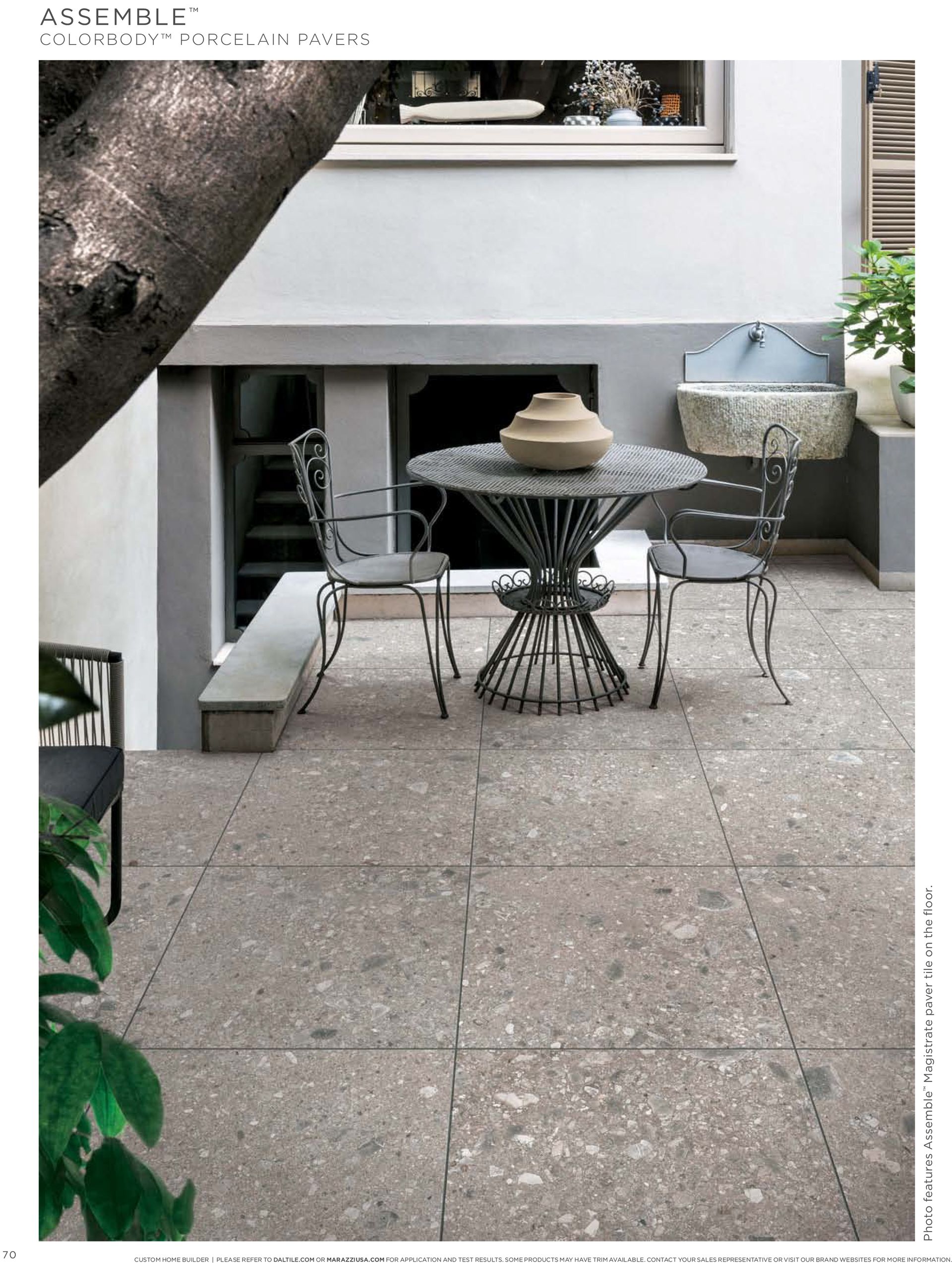A patio with a table and chairs in front of a building.
