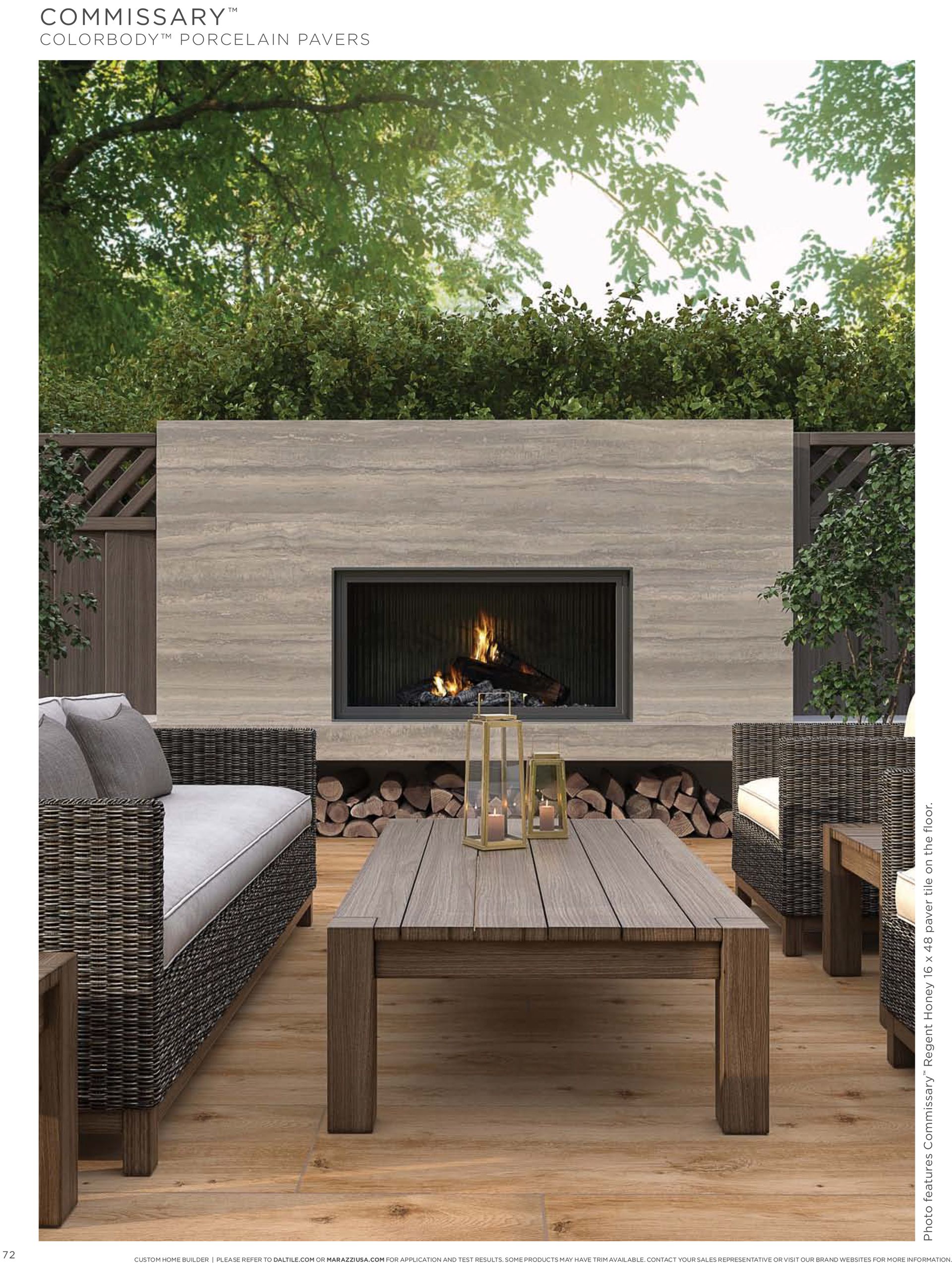 A patio with a fireplace , couch , chairs and a coffee table.