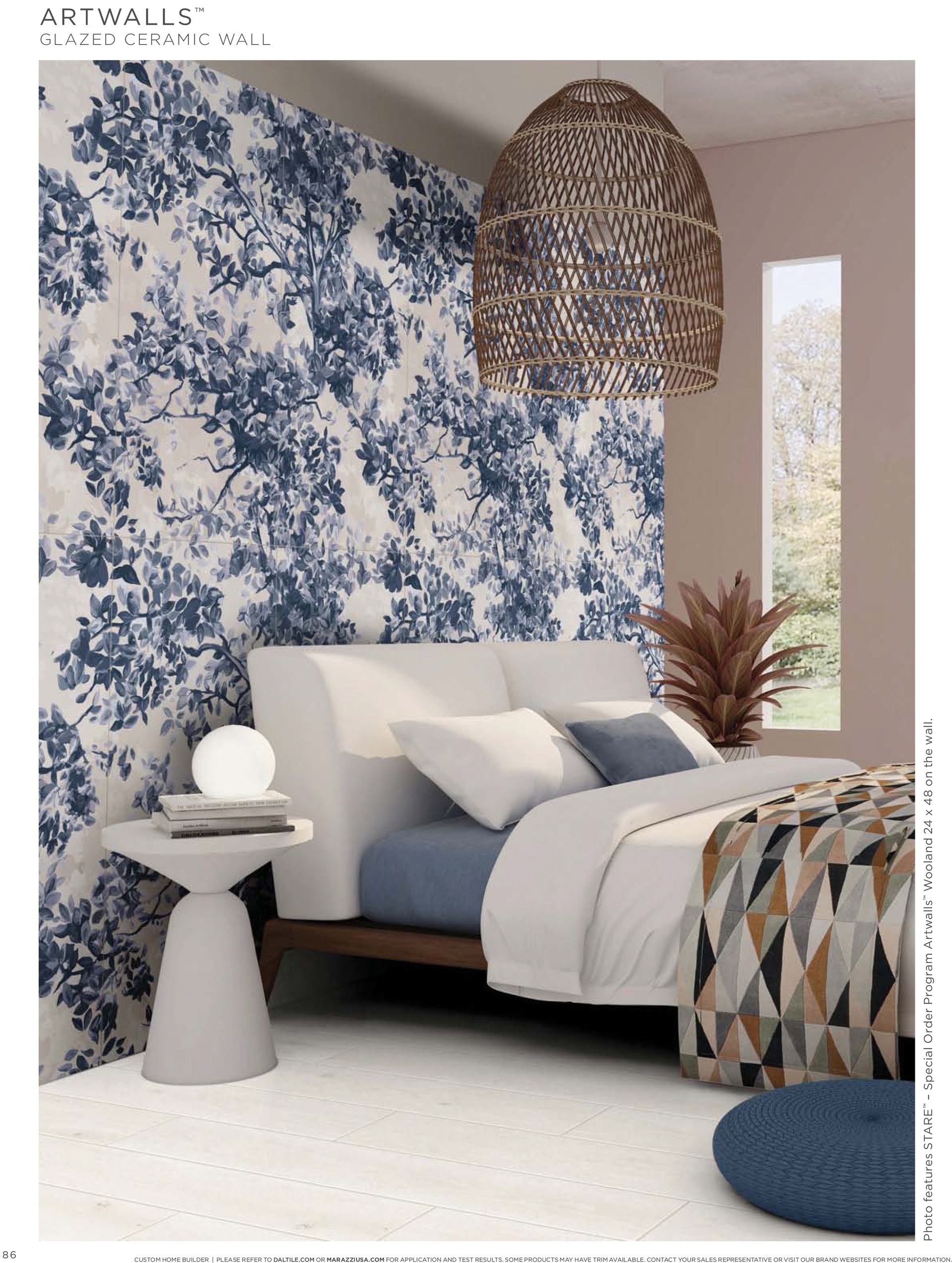 A bedroom with a bed , nightstand , and blue and white floral wallpaper.