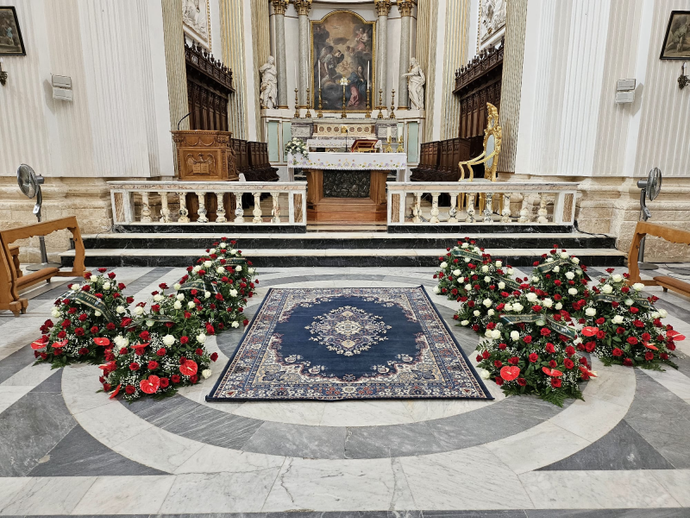 L'interno di una chiesa decorato con fiori e un tappeto.