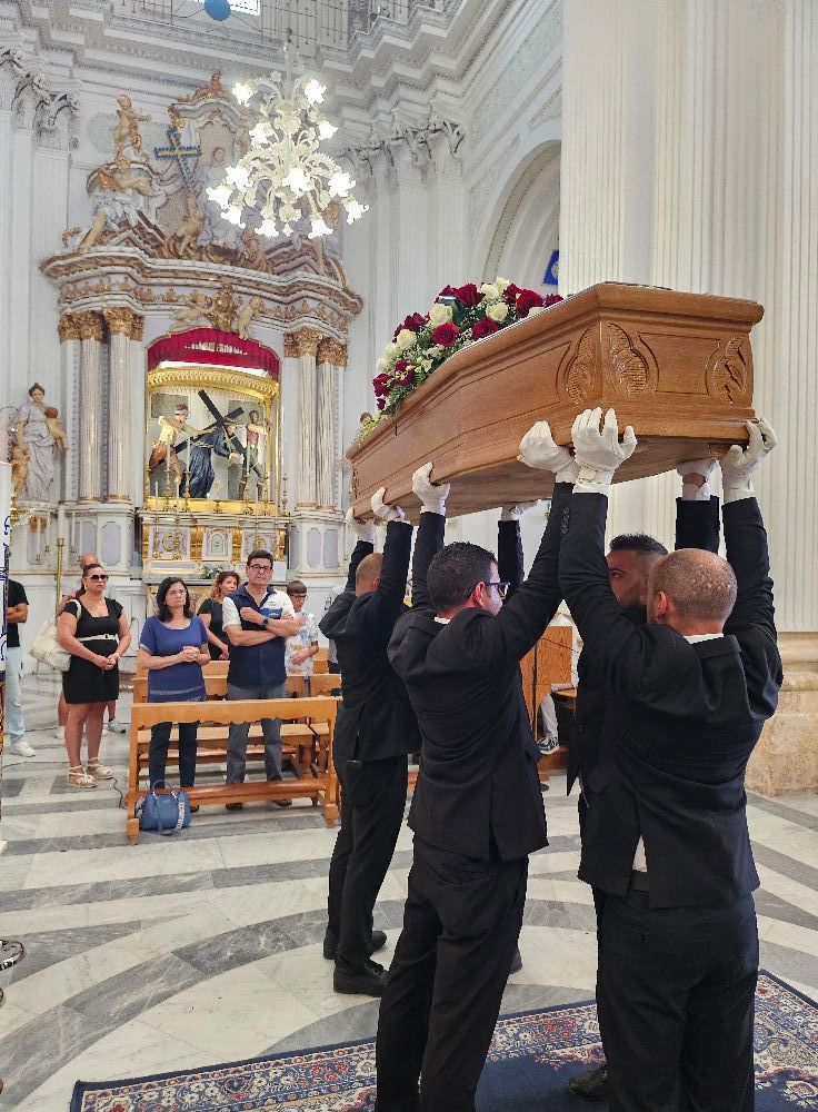 Un gruppo di uomini trasporta una bara in una chiesa
