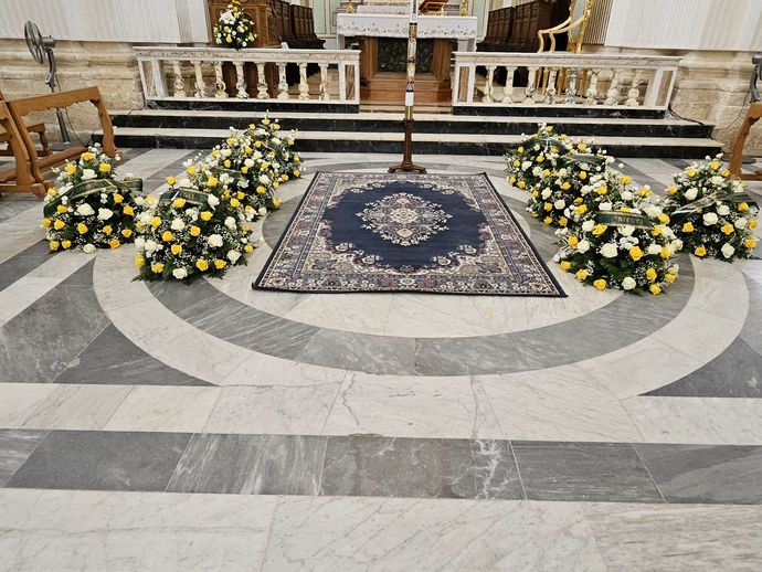 Una chiesa con un tappeto e dei fiori sul pavimento.