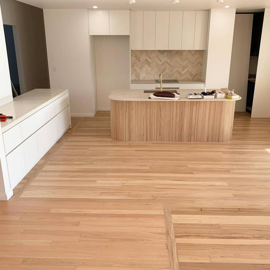 Kitchen With Light Wood Floors and Cabinets, a Curved Wooden Island — CM Timber Flooring in Byron Bay, NSW