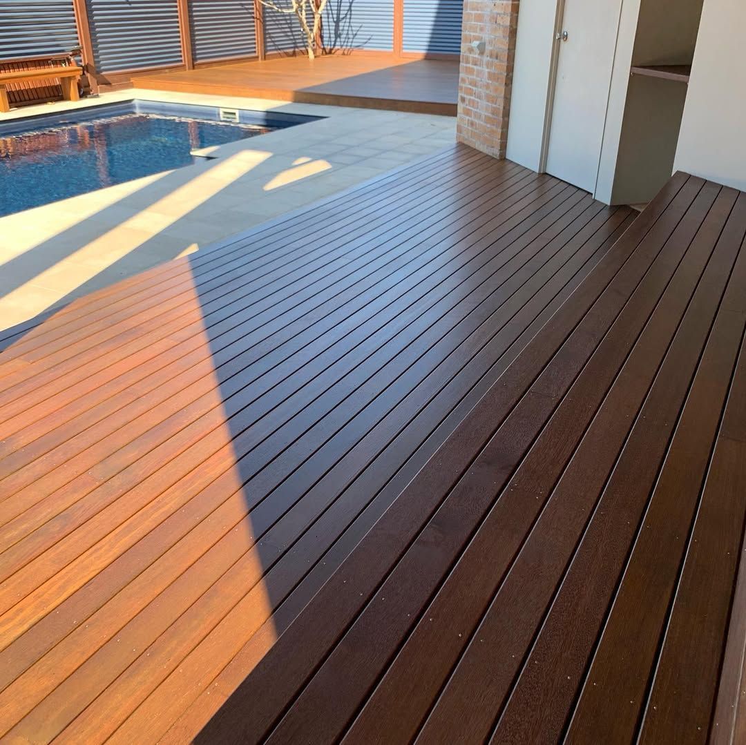 Wooden deck beside a pool, bathed in sunlight — CM Timber Flooring in East Ballina, NSW