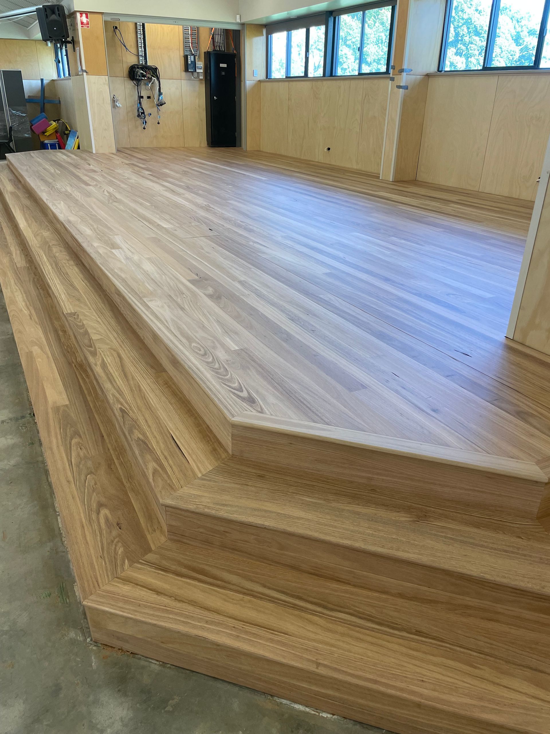 Wooden multi-level floor in a room. Stair-like structure leads up to the main floor — CM Timber Flooring in East Ballina, NSW
