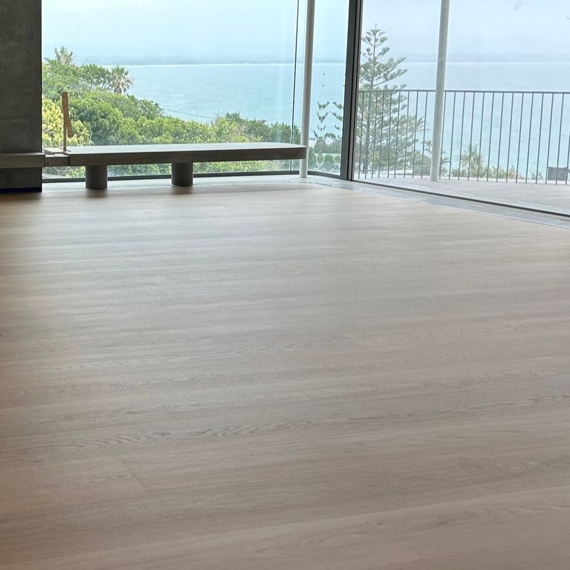 Hands Placing a Wooden Plank on Deck Framing, Outdoor Setting — CM Timber Flooring in East Ballina, NSW