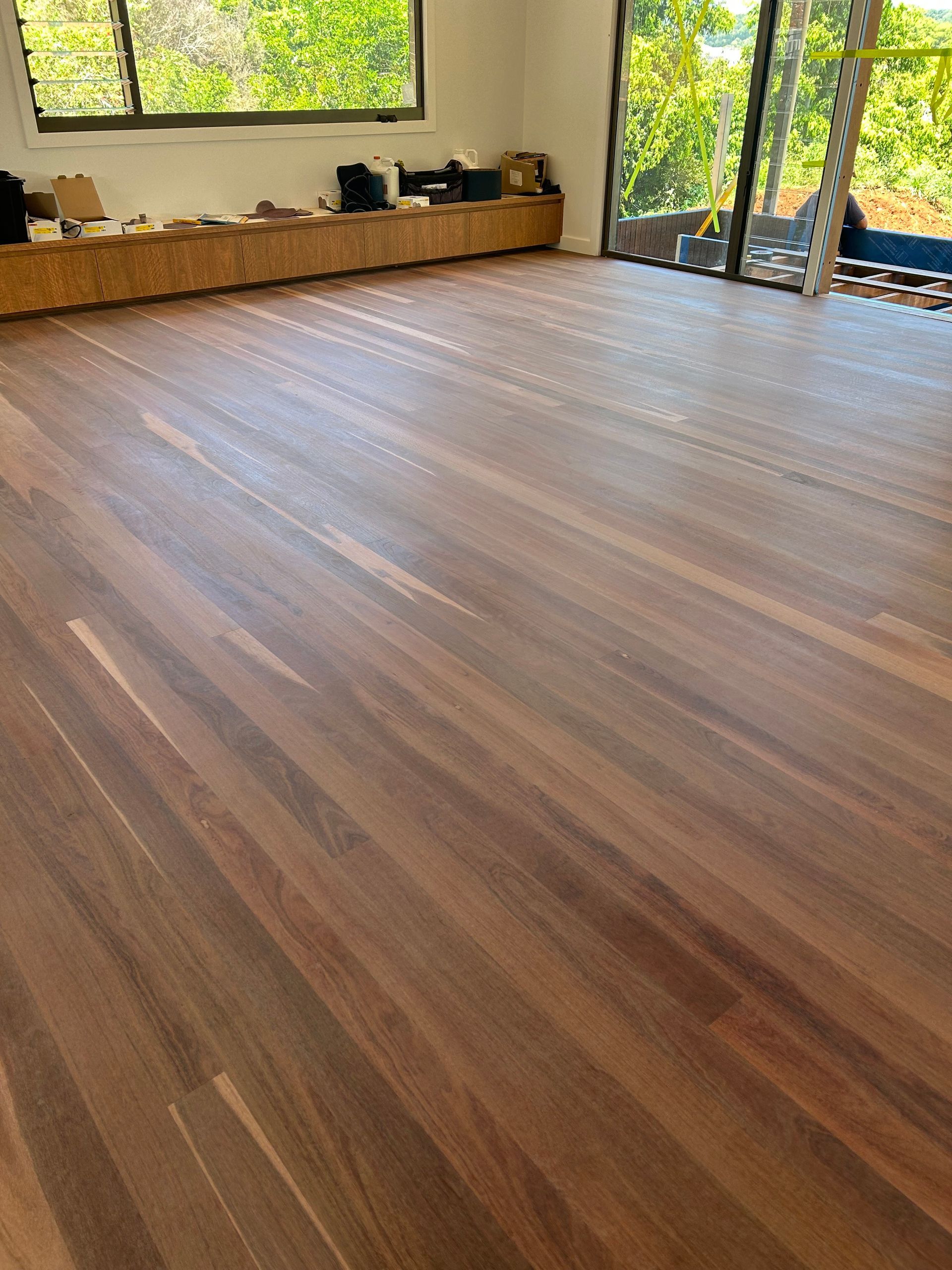 Wooden Floor With Sunlight and a Fireplace in a Modern Room With Large Windows — CM Timber Flooring in East Ballina, NSW