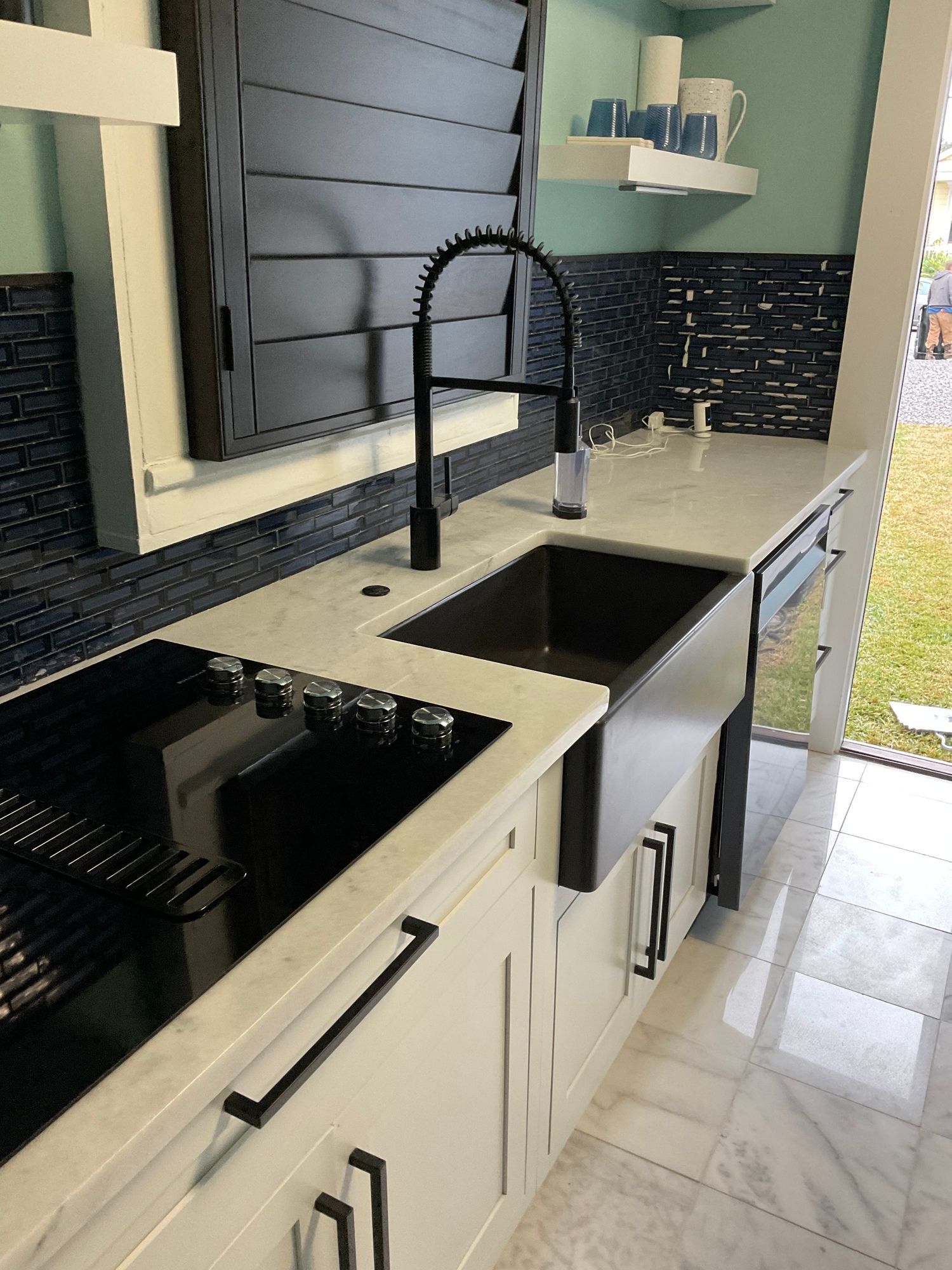A kitchen with white cabinets and a black sink