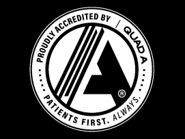 A black and white logo reading Proudly Accredited by QUAD A