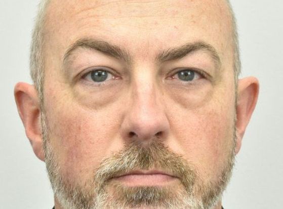 A close up of a man 's face with a beard.