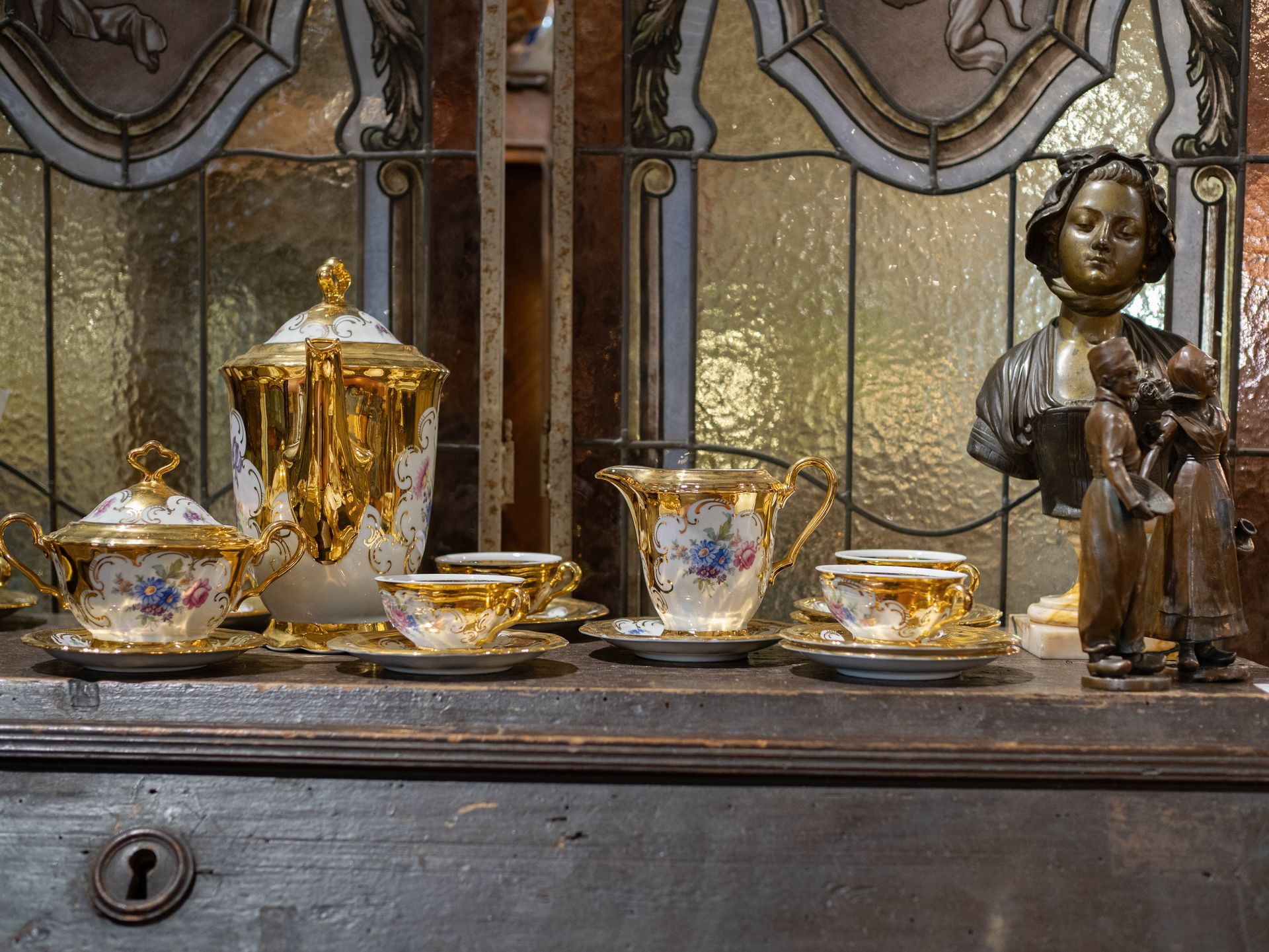 Trucks transporting shipping containers at a port, containers stacked high under a crane, blue sky.