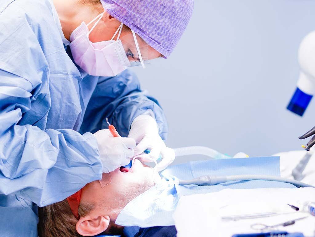 Oralkirurg som behandler pasient