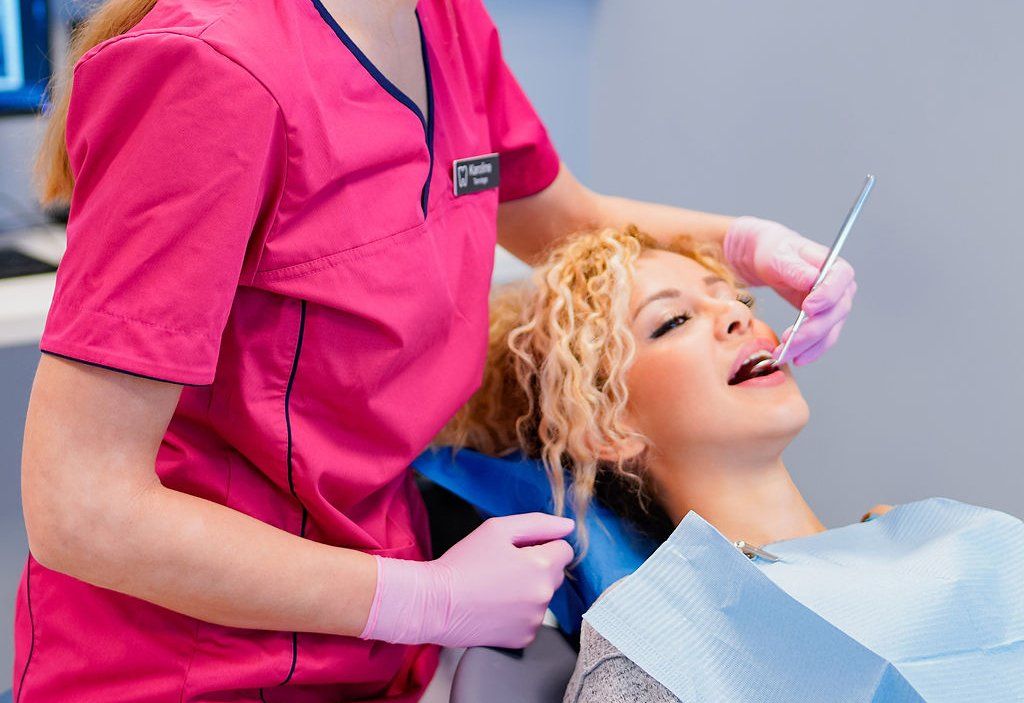 Tannlege som undersøker tennene til en pasient.