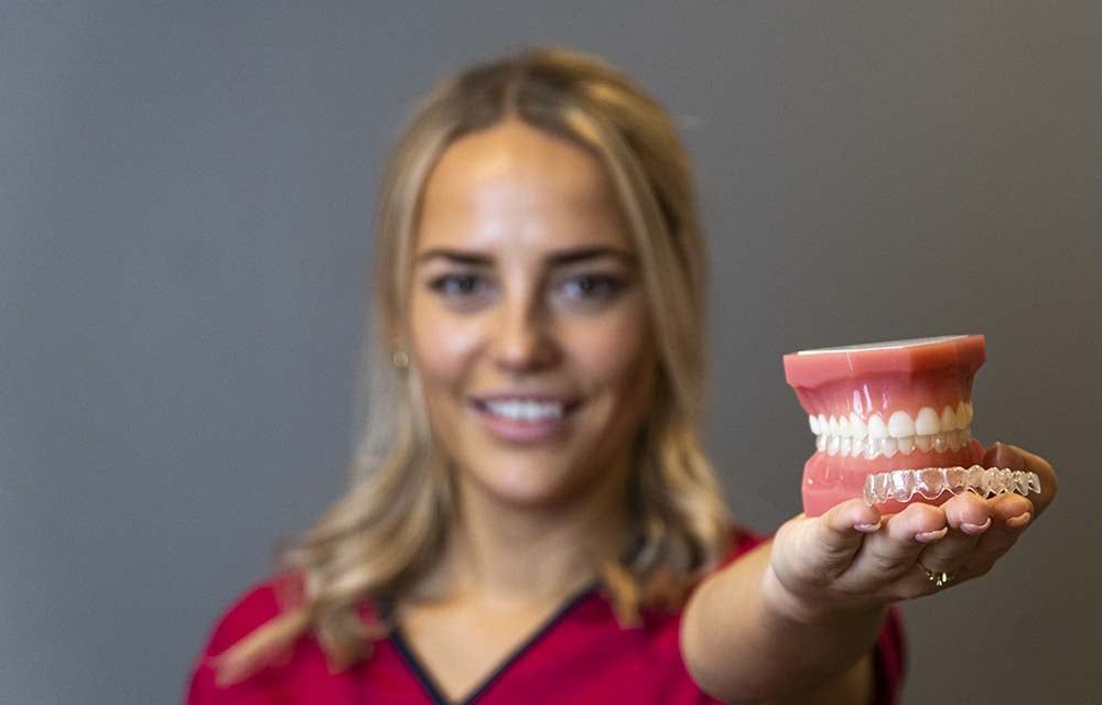 En tannlege hos Clear Tannlegesenter som holder en invisalign usynlig tannregulering