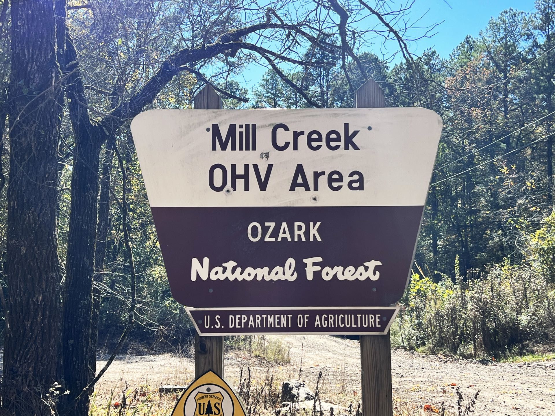 Mill Creek OHV Area sign in a wooded Ozark National Forest setting