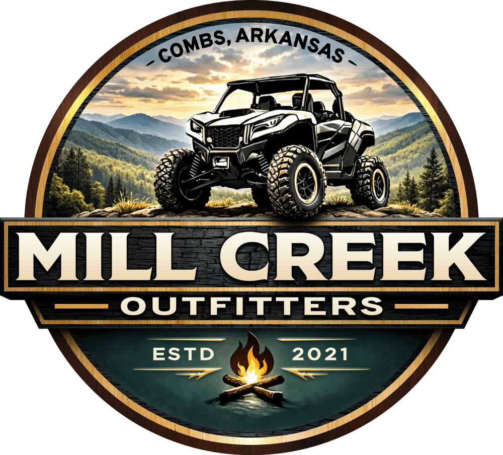 Circular logo for Mill Creek Outfitters in Combs, Arkansas, featuring an ATV on a mountain backdrop above a campfire.
