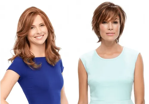 Two women wearing wigs, one with long red hair smiling, the other with short brown hair.