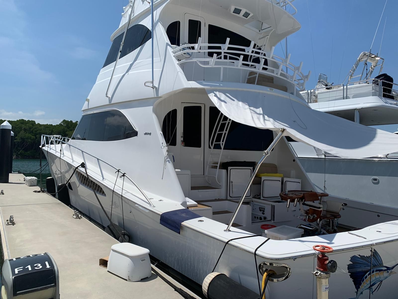 White and Black Motorboat on Stands, Covered in Blue Tarps, Outdoors — Ocean Mate Marine Services in Coomera, QLD