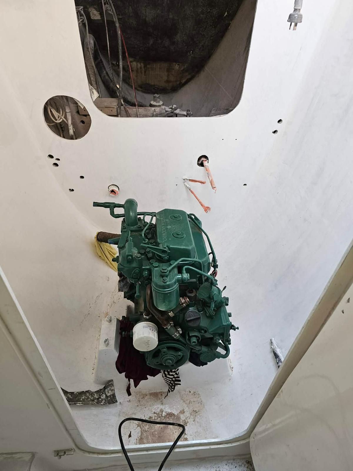 A green marine engine sits centered in the open white engine compartment of a boat. — Ocean Mate Marine Services in Coomera, QLD
