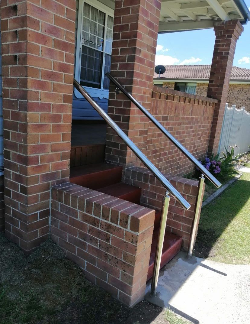 A brick porch with stairs and a metal railing — Saving Time In Charlestown NSW