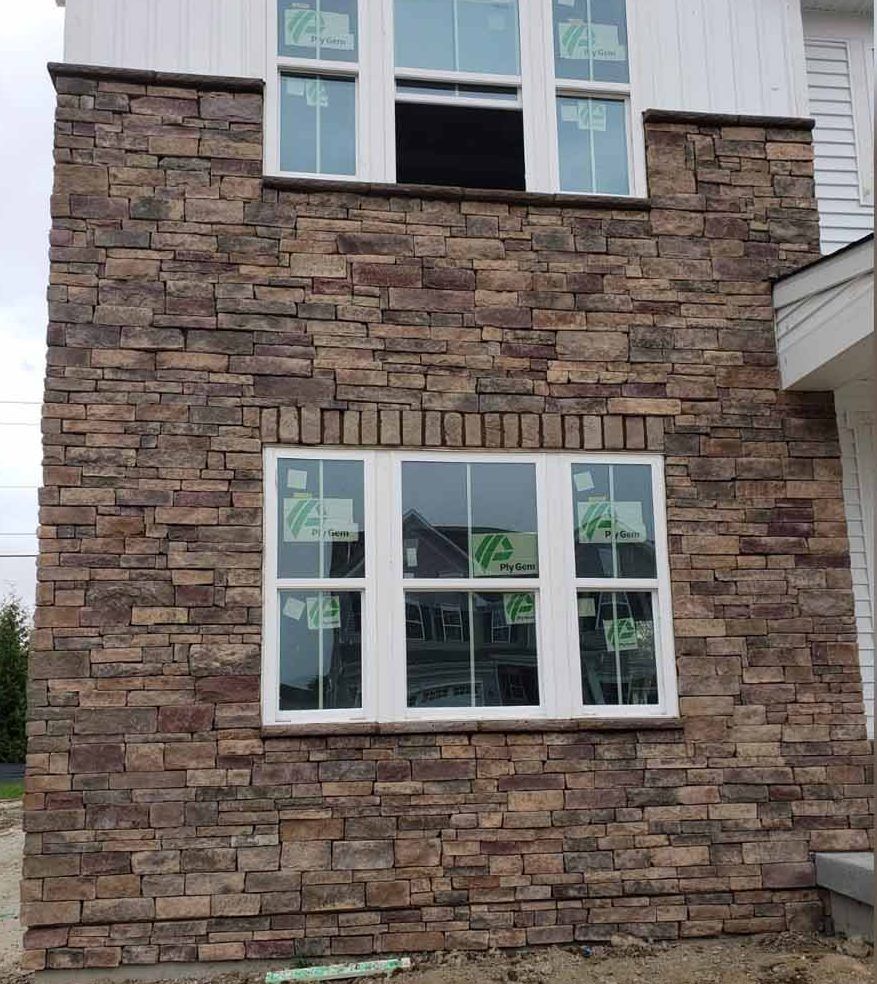 a house with a stone facade and white windows