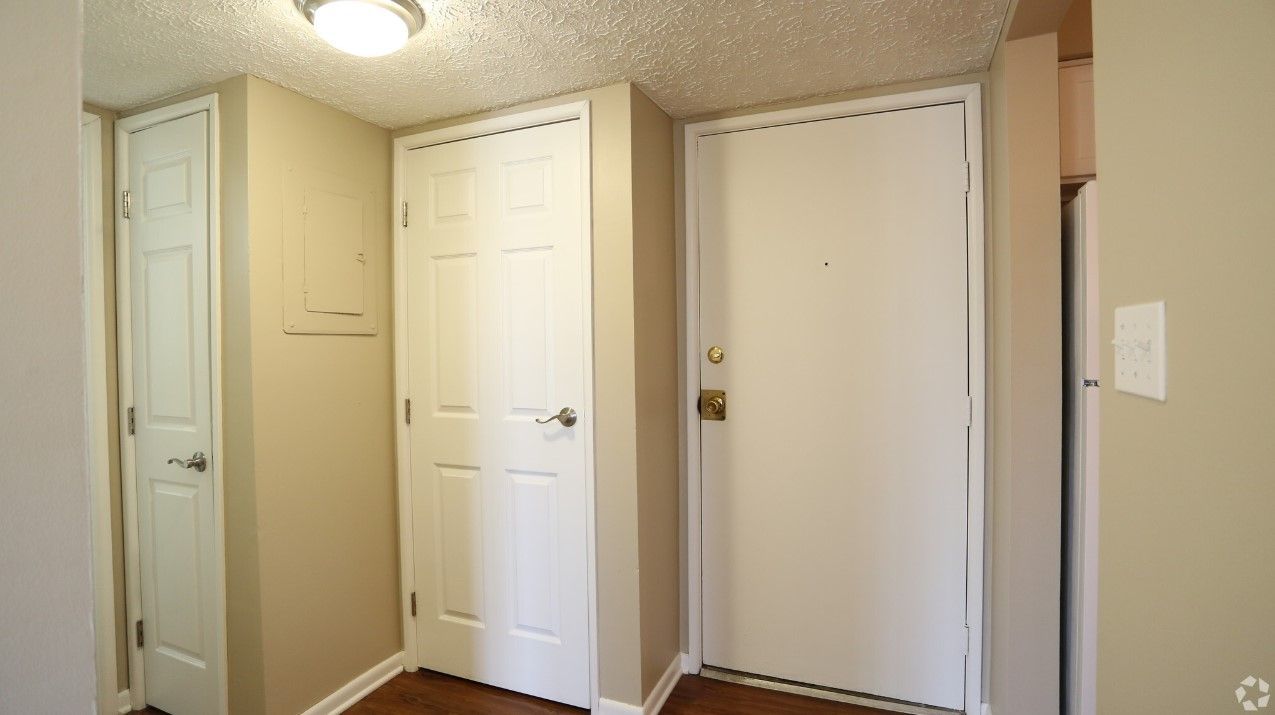 A hallway with two white doors and a light on the ceiling.
