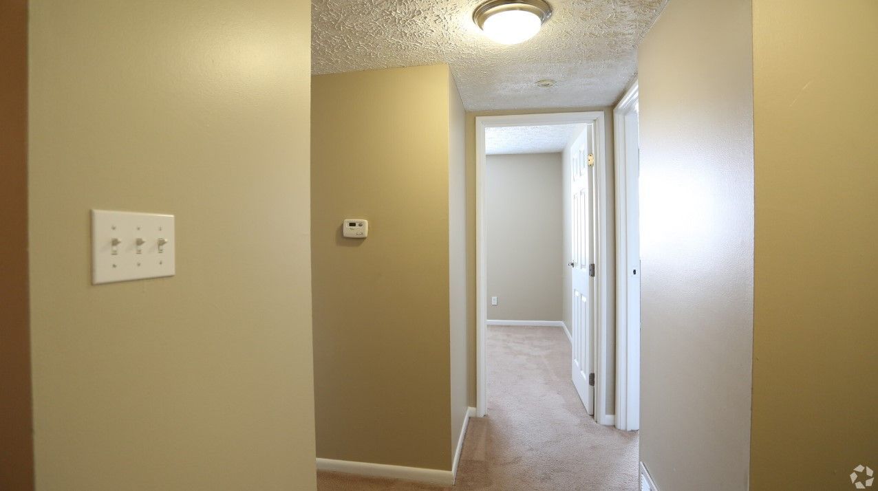 An empty hallway in a house with a light on the ceiling.