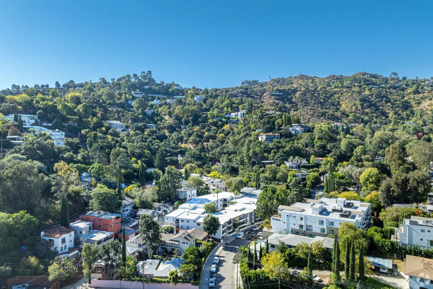 Houses nestled in a green hillside, sunny day.