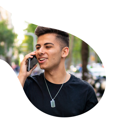 A young man in a black shirt is talking on a cell phone