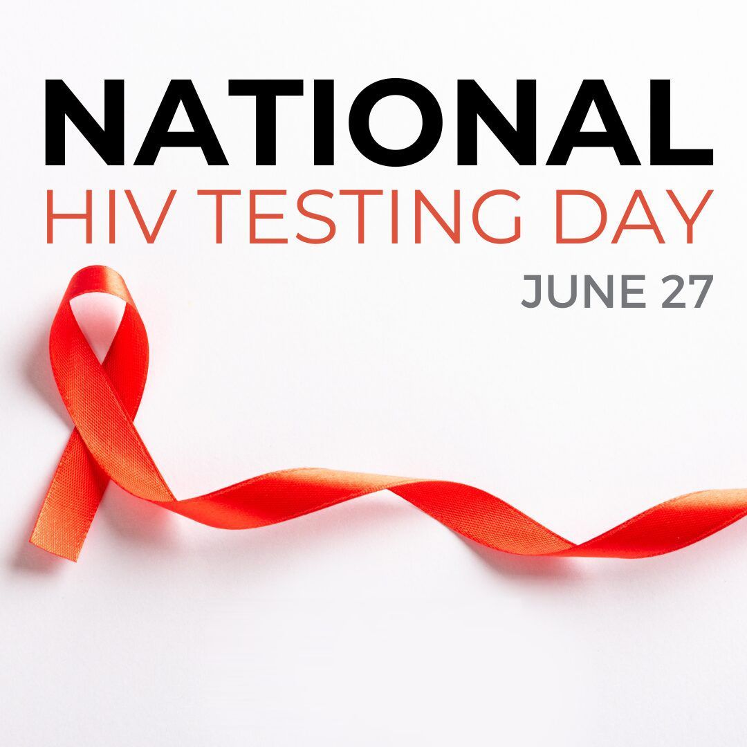 A red ribbon is on a white background for national hiv testing day.