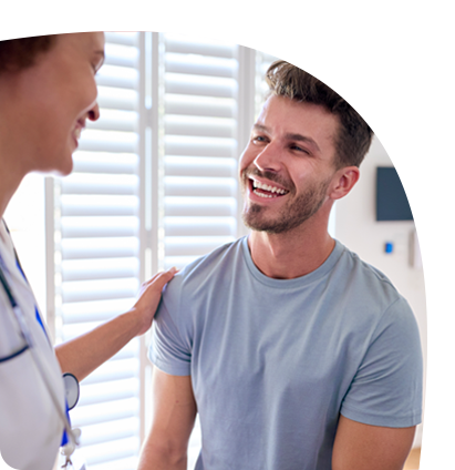 A man is smiling while talking to a doctor.