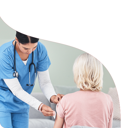 A nurse is giving a woman a vaccine in her arm.