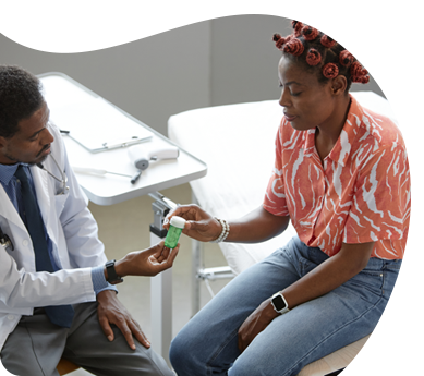 A doctor is giving a woman a bottle of pills
