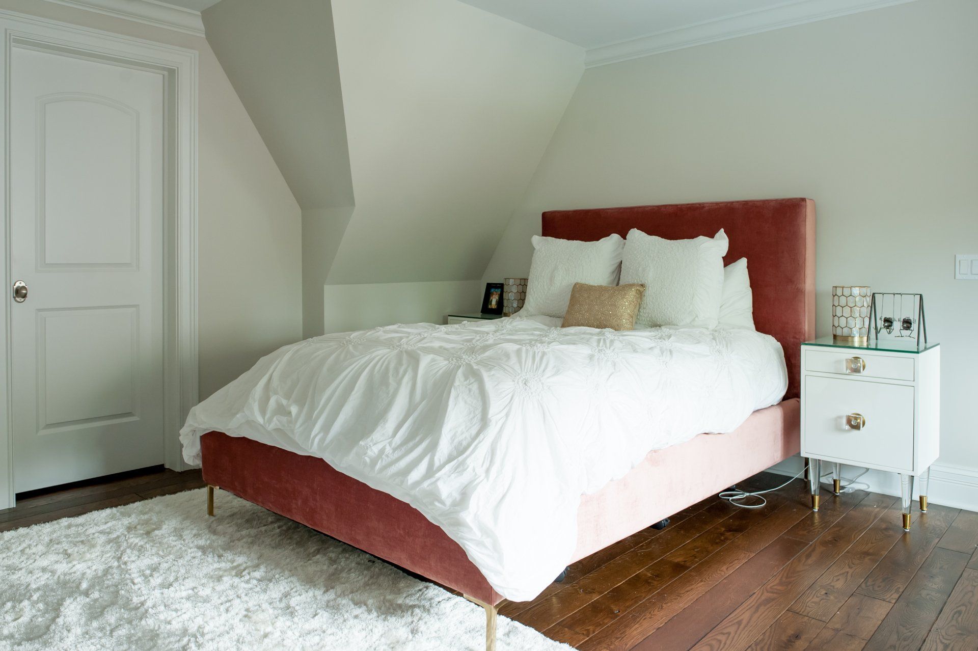 A bedroom with a bed , nightstand , and rug.