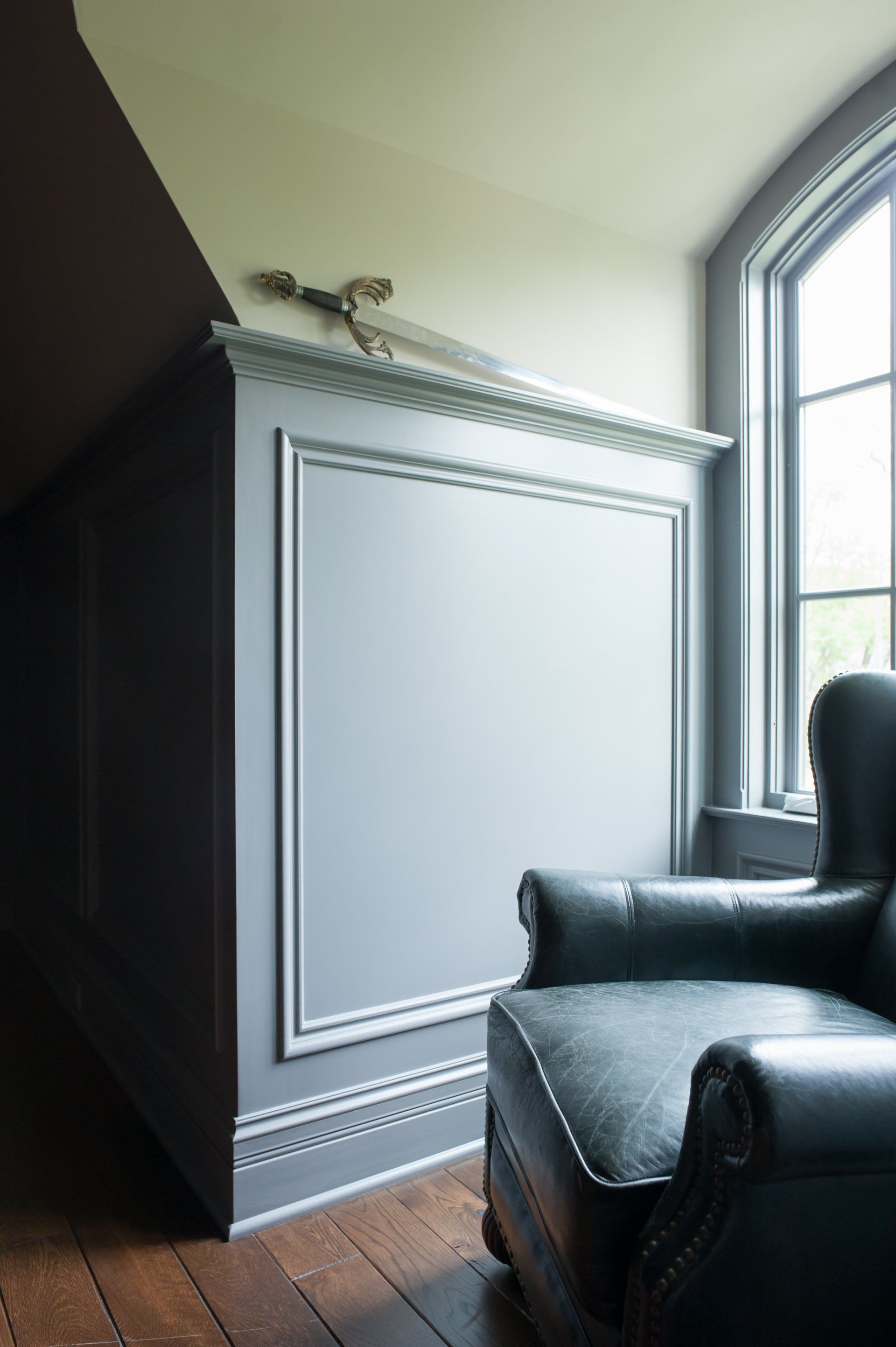 A chair is sitting in a room next to a window.