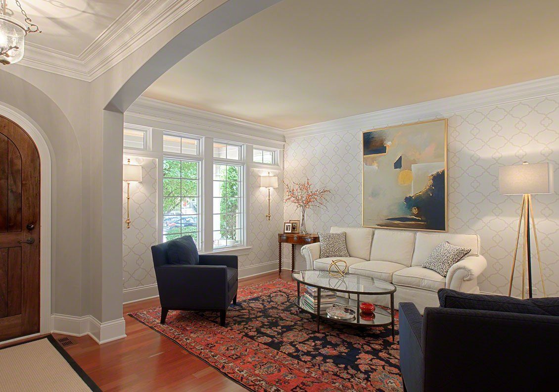 A living room with a couch , chairs , and a coffee table.