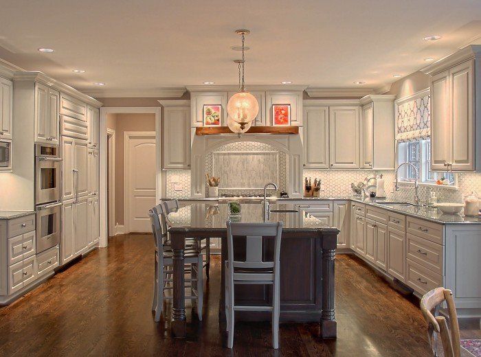 A kitchen with white cabinets and a large island in the middle.