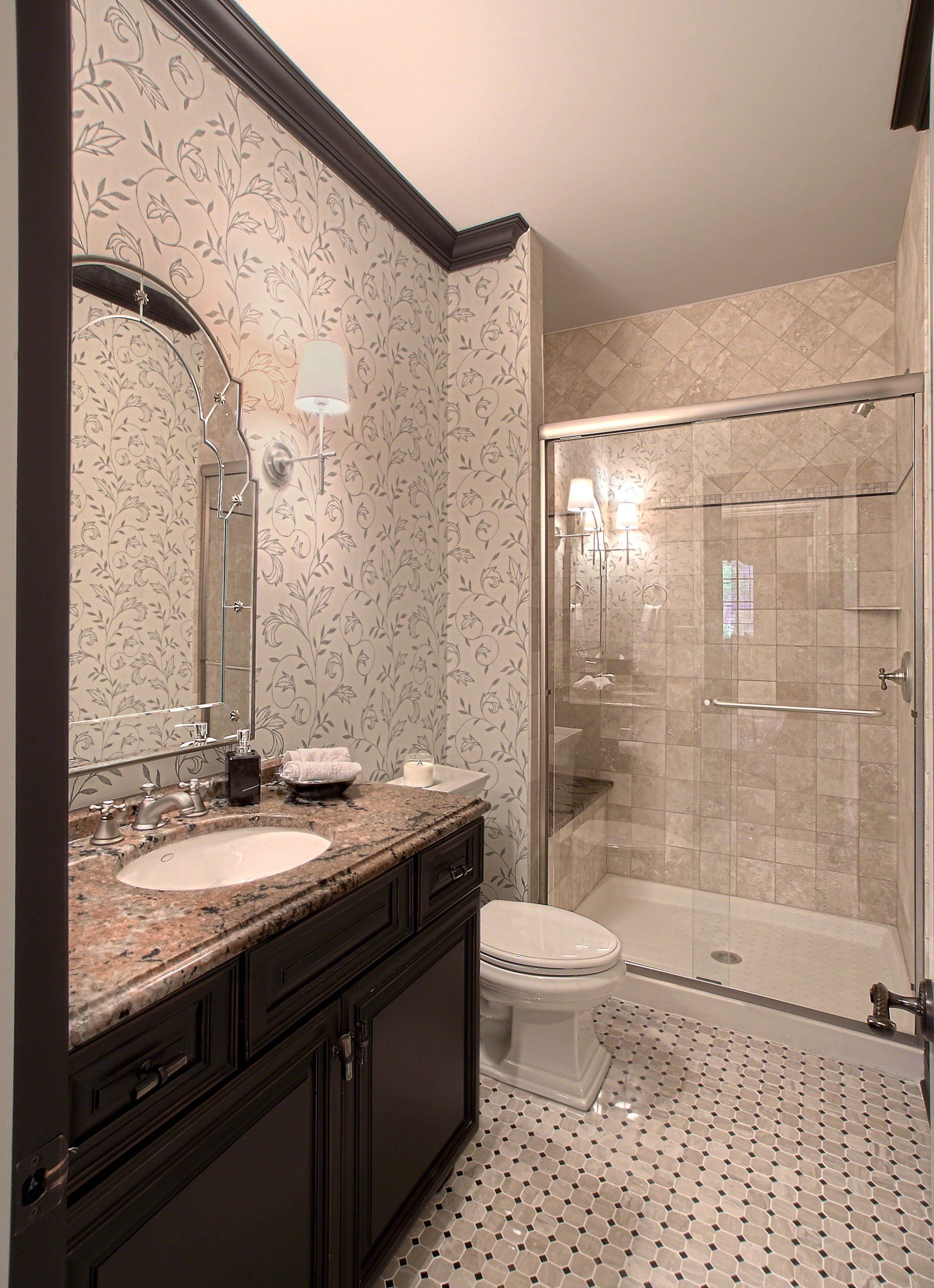 A bathroom with a toilet , sink , mirror and shower.