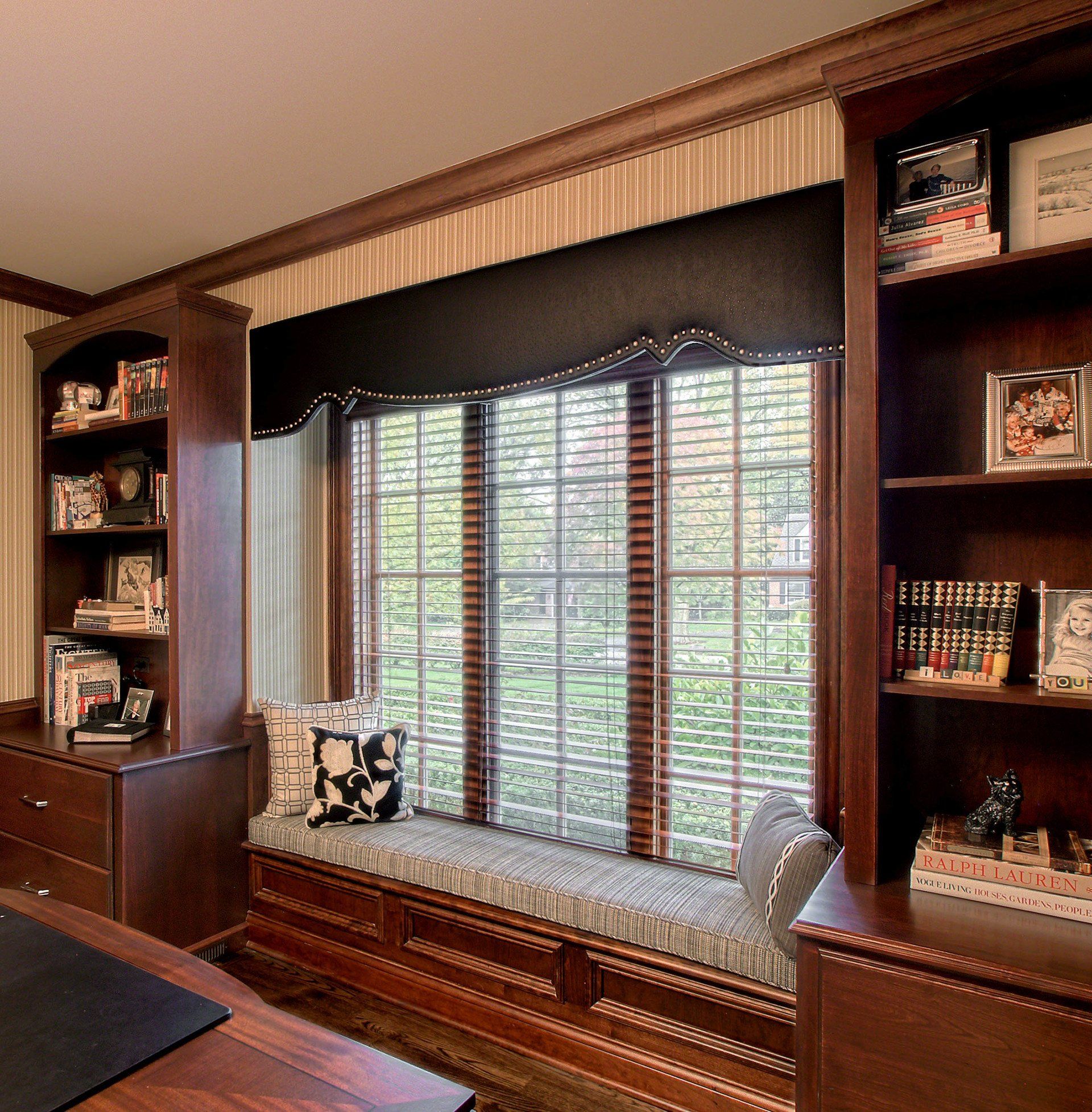 A room with a bookshelf and a window seat