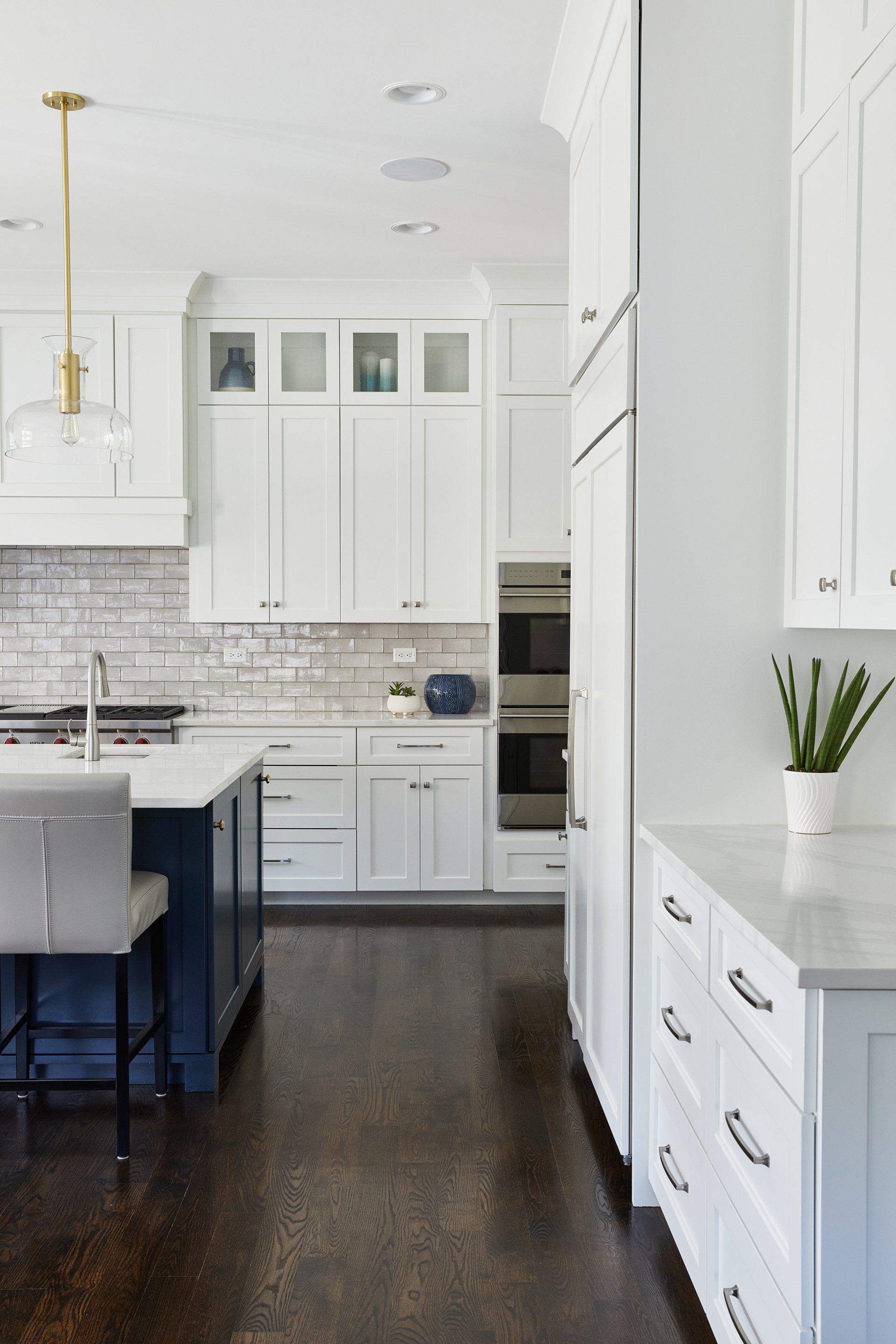 A kitchen with white cabinets and a blue island