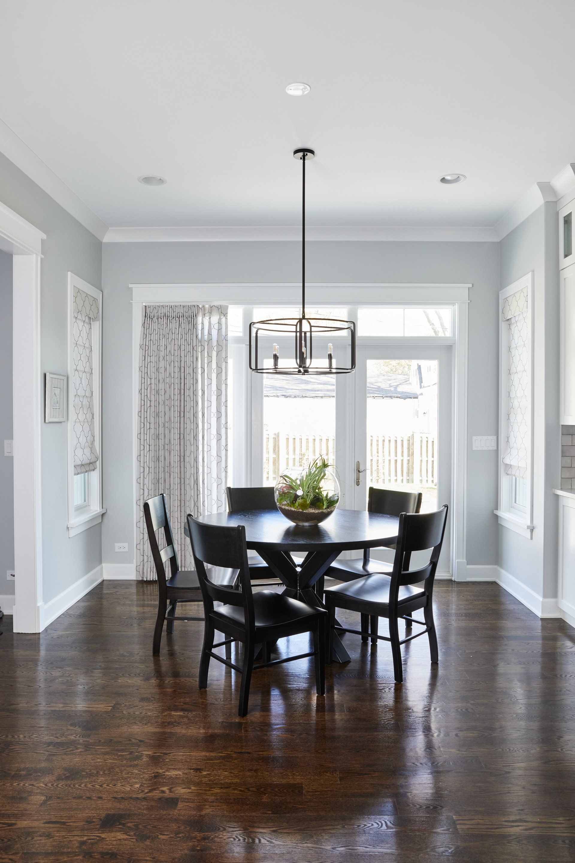 A dining room with a round table and chairs and a chandelier.