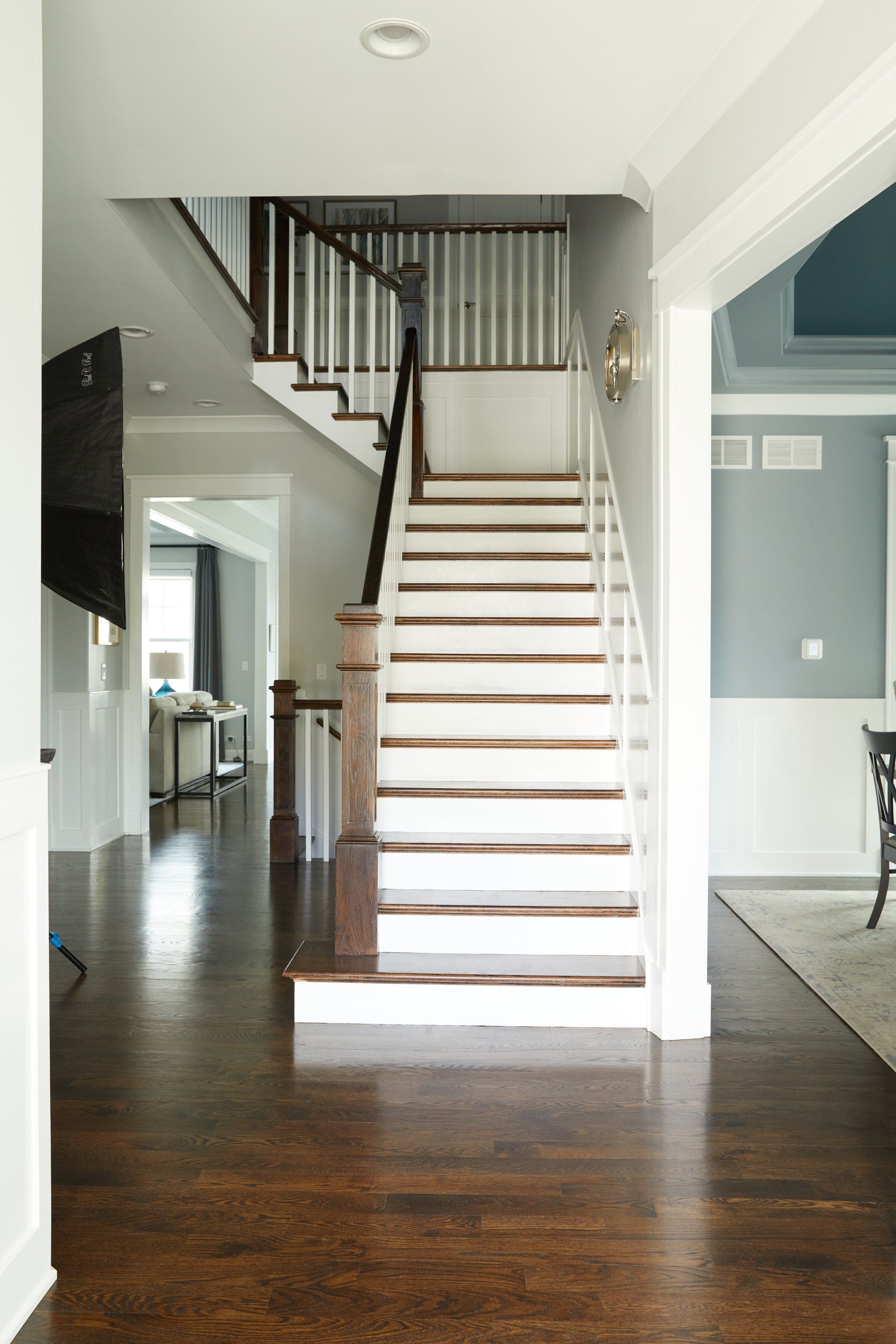 A staircase in a house with white steps and a wooden railing