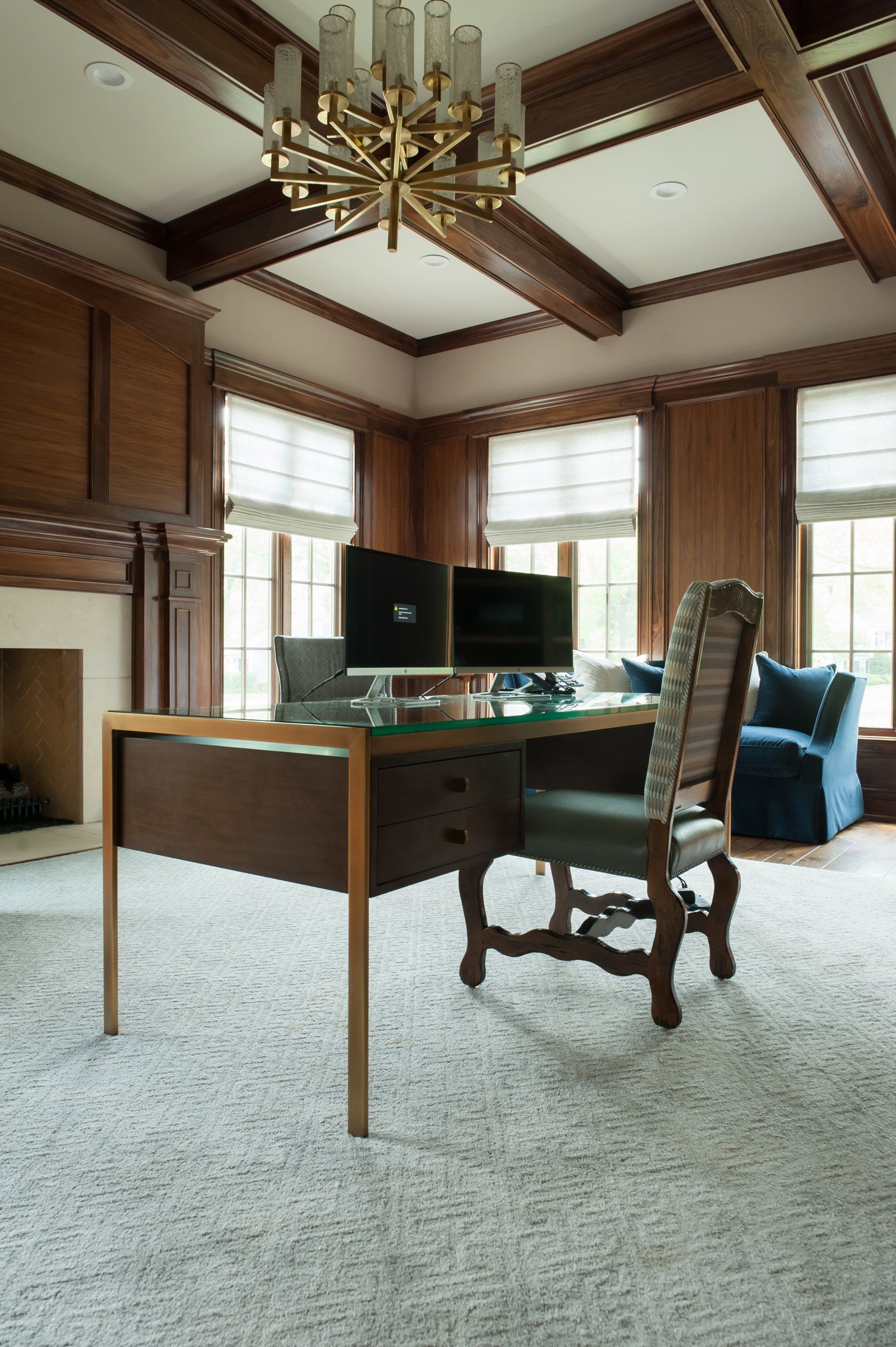 A home office with a desk , chair , computer and fireplace.