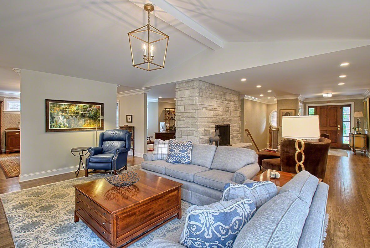 A living room with a couch , chair , coffee table and fireplace.