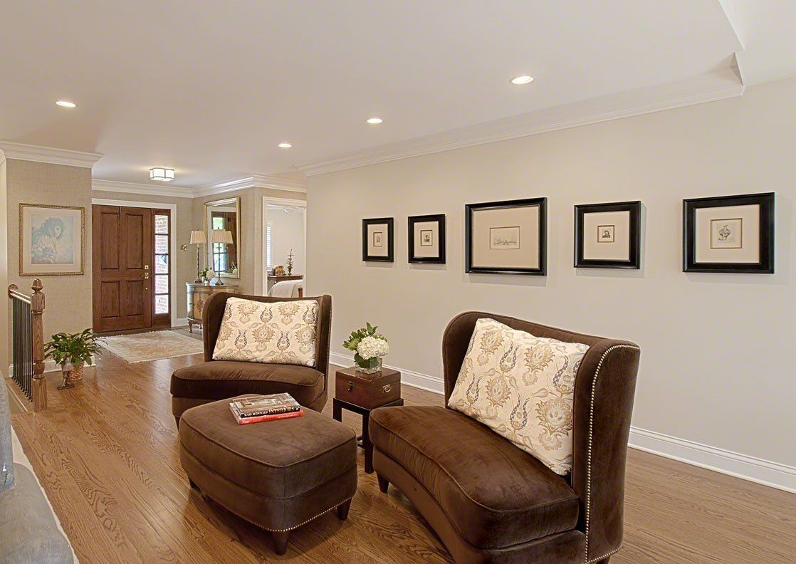A living room with a brown couch and two chairs